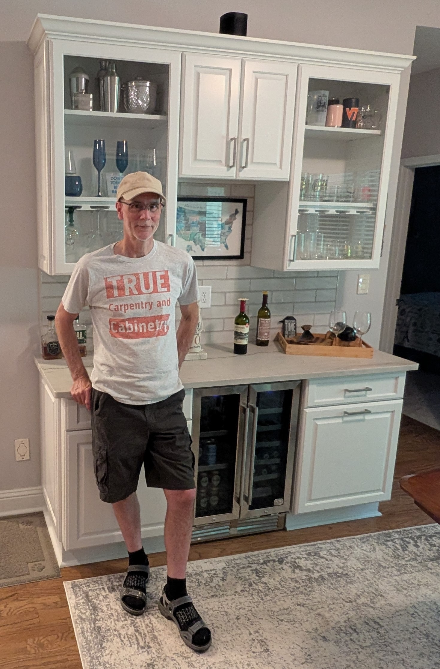 Stewart True beside custom white cabinetry, June 2026